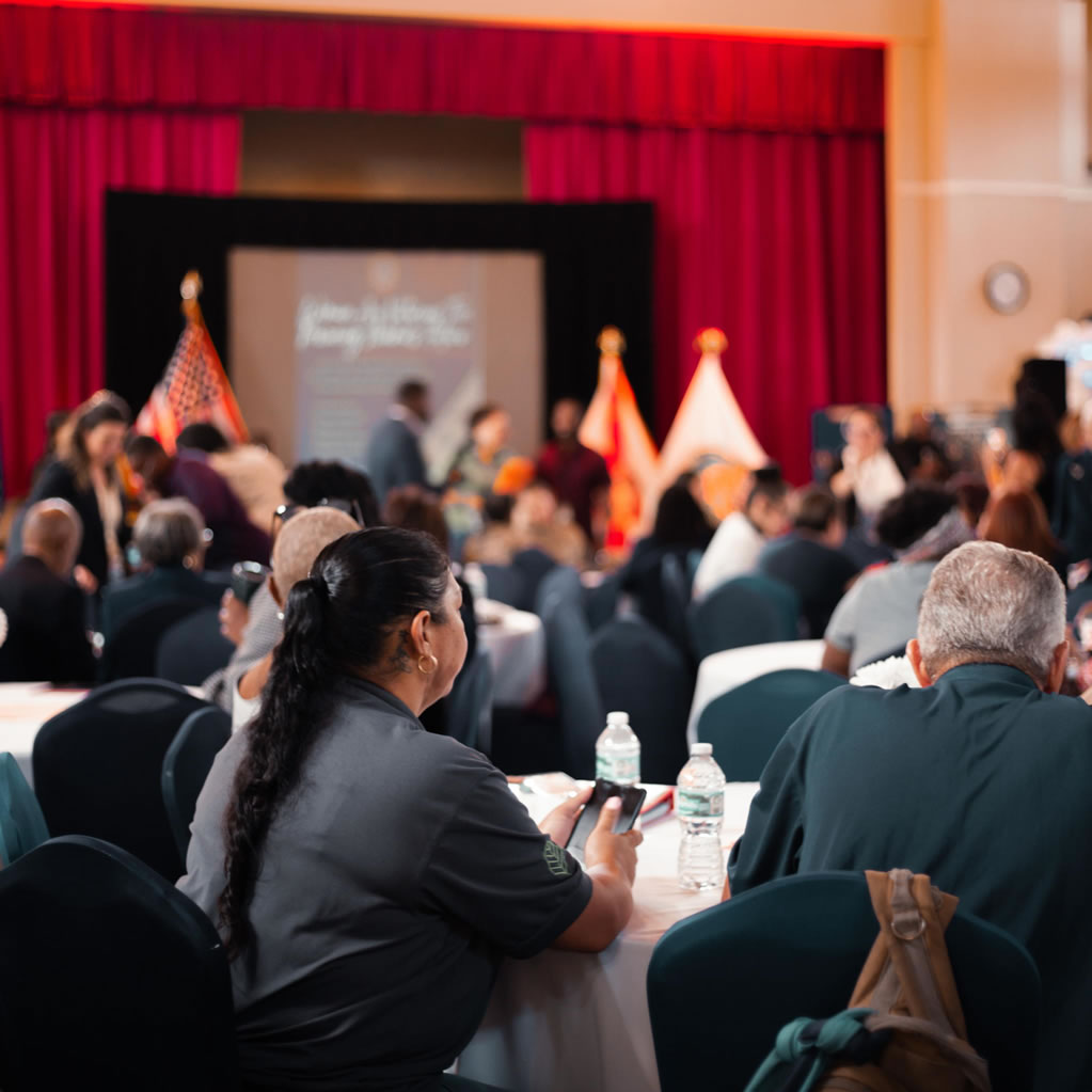 Wide view of the audience seated at tables during the SDWVA program