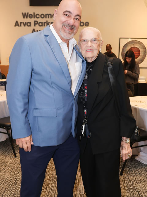 Man in a blue blazer embracing an elderly woman veteran at an SDWVA event