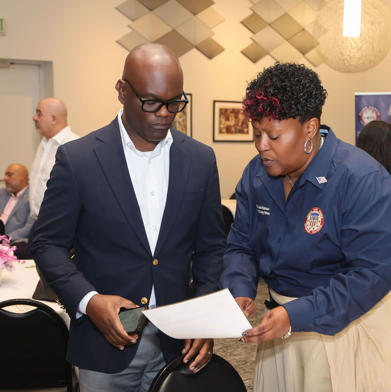 Man and a uniformed SDWVA team member reviewing a document together
