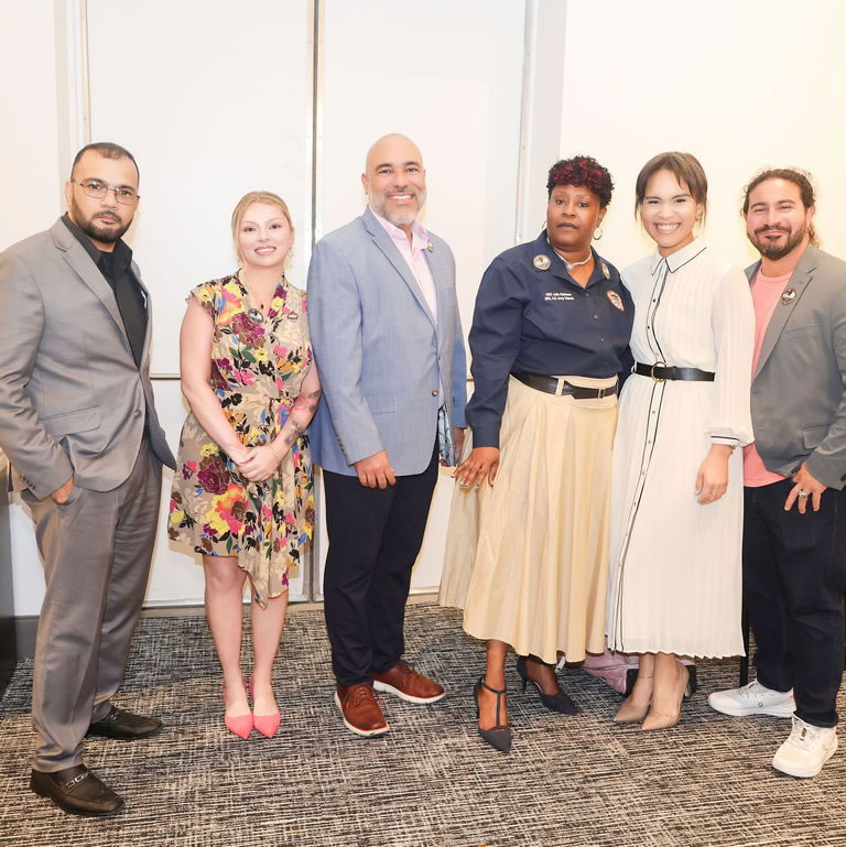 Group of six SDWVA supporters posing together at an event